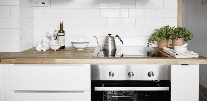 Horno a gas con panel frontal plateado.