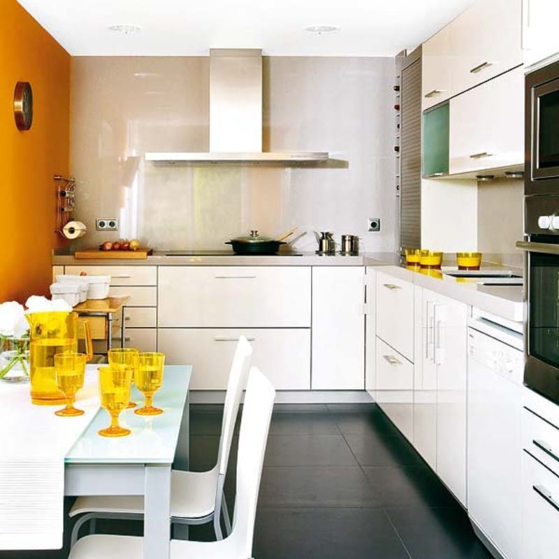 Accentwand van oranje kleur in het interieur van de keuken met lage plafonds