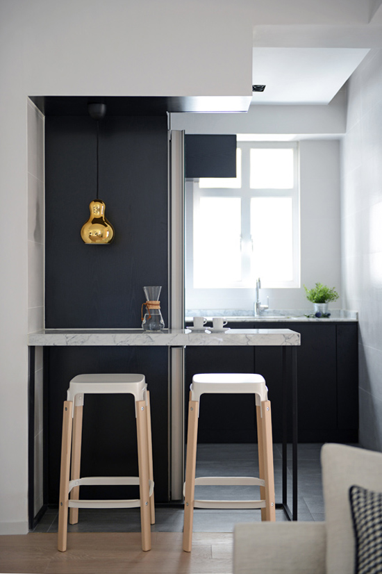 Gouden lamp in zwart-witte keuken