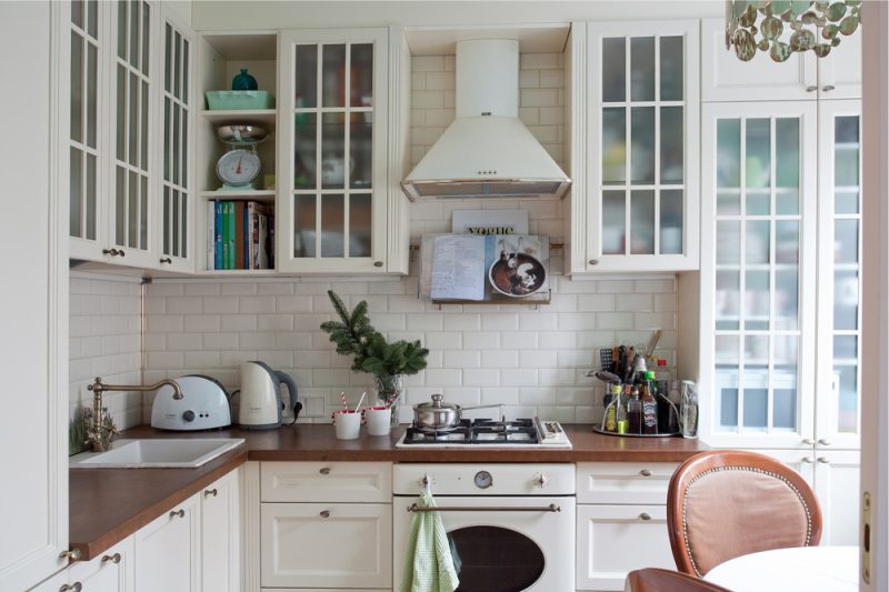 Cocina blanca con mesada de madera.