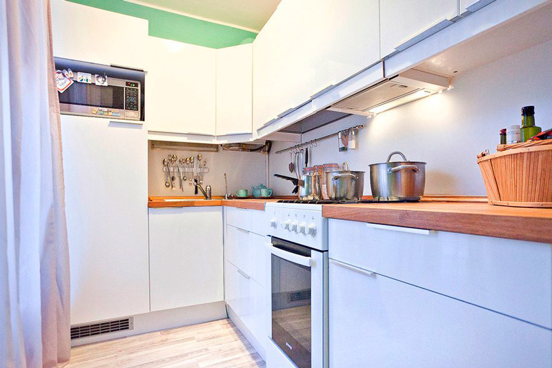 Pequeña cocina con nevera pequeña.