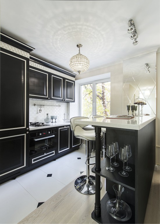 Cocina negra con encimera blanca.