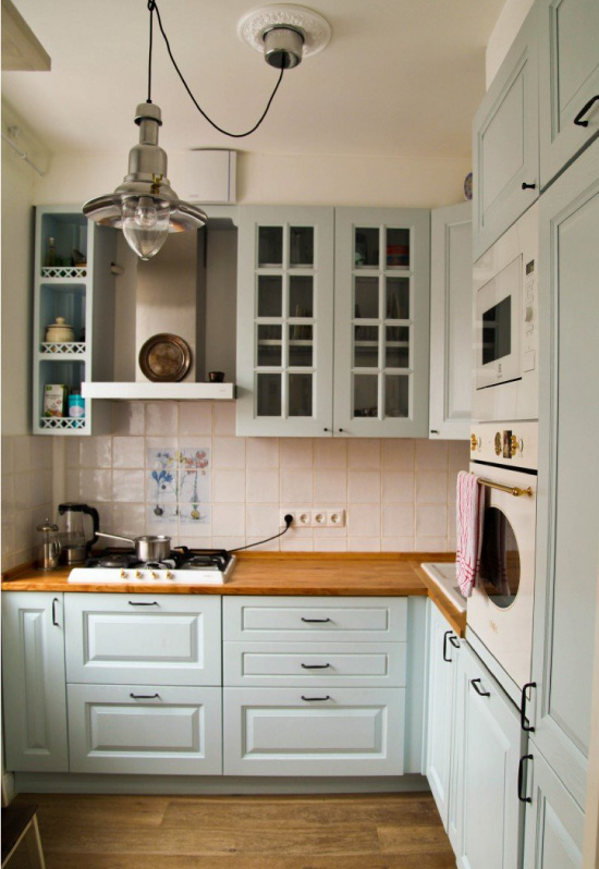Cocina azul con encimera de madera.