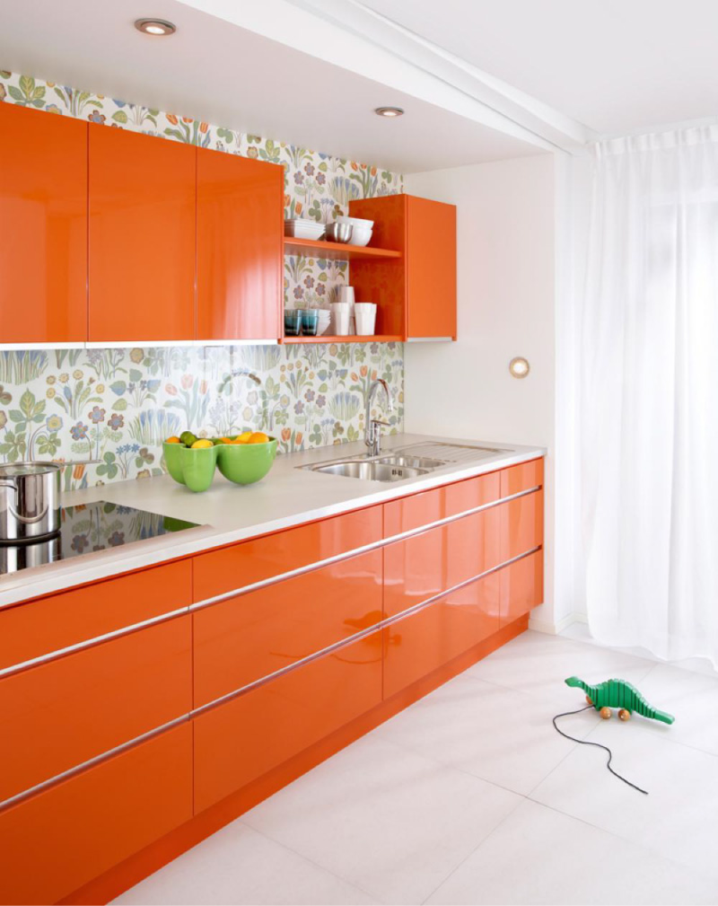 Cocina naranja con encimeras blancas.